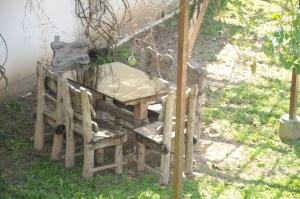 una mesa de madera y sillas sentadas en el césped en Residencial Gil, en Palhoça