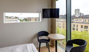 Go Hotel City Apartments في كوبنهاغن: غرفة بطاولة وكرسيين ونافذة