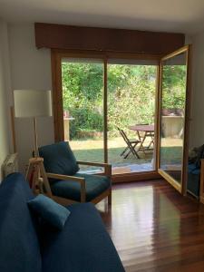 a living room with a couch and a table at Casa de Claudia Comillas- Jardín privado - A 10 metros del Capricho de Gaudí in Comillas