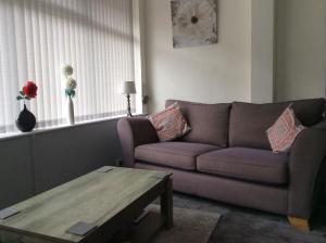 uma sala de estar com um sofá, uma mesa e uma janela em Brene Hotel em Blackpool