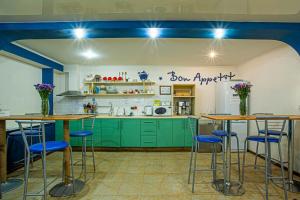 a kitchen with green cabinets and blue stools at Gar'is Hostel Kyiv in Kyiv