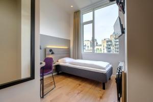 ein kleines Schlafzimmer mit einem Bett und einem Fenster in der Unterkunft Go Hotel City in Kopenhagen