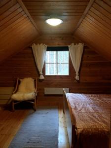 a attic room with two beds and a window at PyhäBerry in Pelkosenniemi
