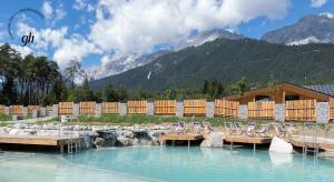 a group of chairs sitting on a dock in the water at Hotel & Glamping Gerhardhof by ALPAMI in Wildermieming