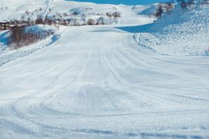 een besneeuwde weg met sporen in de sneeuw bij Haukelifjell Skisenter in Vågsli