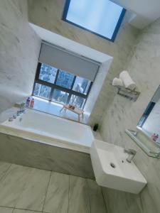 een badkamer met een wit bad en een raam bij Imperio Residence Bathtub Studio Melacca Town-FreeParking in Melaka