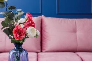 a blue vase with red and white flowers on a couch at Apartament przy Bulwarach Wiślanych Kościuszki by Renters in Krakow
