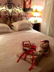 Montalto delle MarcheにあるCasannunziata - appartamento con 2 camere no cucinaの白いベッド(赤いリボン付)
