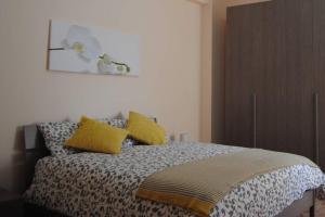 um quarto com uma cama com almofadas amarelas em Eloisa Guest House em Sciacca