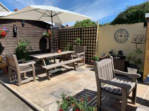 a patio with a table and chairs and an umbrella at No. 5 Smith Cottages in Langport