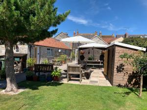 a backyard with a picnic table and an umbrella at No. 5 Smith Cottages in Langport