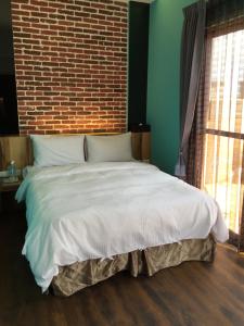 Een bed of bedden in een kamer bij Penghu Little Apple B&B
