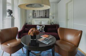 a living room with a couch and a table and chairs at House of Hütter - Heidelberg Suites & Spa in Heidelberg