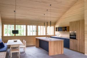 una cucina con pareti in legno, un tavolo e una sala da pranzo di Fuchsegg Eco Lodge a Egg