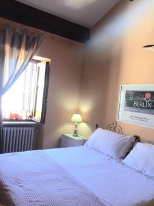Montalto delle MarcheにあるCasannunziata - appartamento con 2 camere no cucinaのベッドルーム(白いベッド1台、窓付)