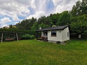 una piccola casa in un cortile con un campo verde di Domek u Cioci Meli a Brodnica Dolna