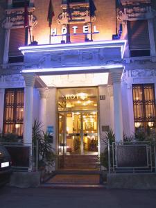 a lit up building with a revolving door at Hotel Mayorca in Milan