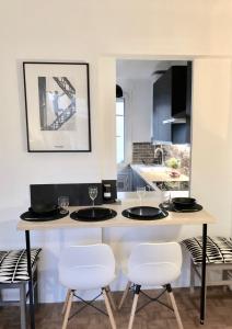 a kitchen with a counter with four chairs and a table at Appartement Pouchard Welkeys in Saint-Mandé