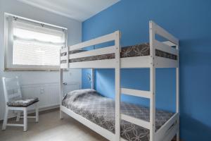 a bedroom with two bunk beds and a chair at Heimathafen in Bremerhaven