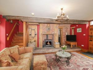 a living room with a couch and a fireplace at Pentre Barn in Abergavenny