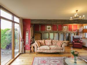 sala de estar con sofá y paredes rojas en Pentre Barn, en Abergavenny