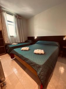 1 dormitorio con 2 camas y toallas. en Hotel Riviera en Córdoba