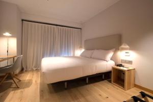 a bedroom with a bed and a lamp at Zenit Sevilla in Seville