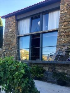 a house with two chairs sitting on a balcony at casa das ameias in Folgosa