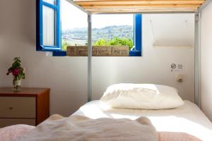 a bedroom with a bed and a window with a sign at Himara Hostel in Himare