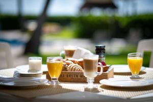 a table with a tray of food and glasses of orange juice at Las Villas Akumal in Akumal