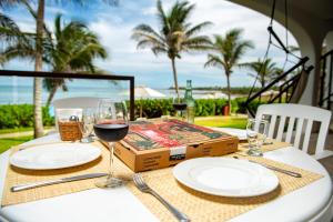 a table with white plates and glasses of wine at Las Villas Akumal in Akumal