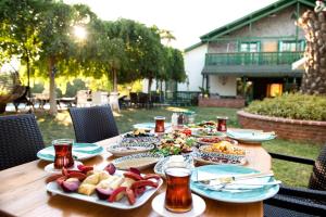 drewniany stół z talerzami żywności w obiekcie My House Urla w mieście Izmir
