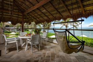 a hammock on a patio with a view of the ocean at Las Villas Akumal in Akumal