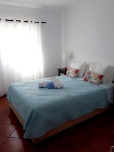 um quarto com uma cama grande e um cobertor azul em Vivenda Privada - Monte Vistoso - Duna Parque Group em Vila Nova de Milfontes