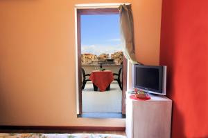 a room with a television and a table with a view at Locanda Scirocco in Castellammare del Golfo