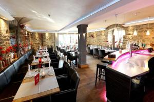 a restaurant with tables and chairs and a bar at Schloss Hotel Burgbrohl in Burgbrohl