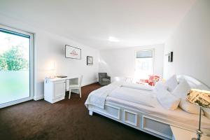 a white bedroom with a large bed and a desk at Schloss Hotel Burgbrohl in Burgbrohl