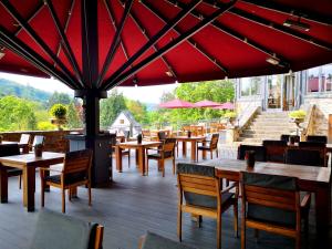 a restaurant with tables and chairs and a red umbrella at Schloss Hotel Burgbrohl in Burgbrohl