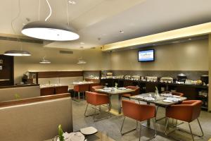 a restaurant with tables and chairs and a bar at The Fern Residency, Vadodara in Vadodara