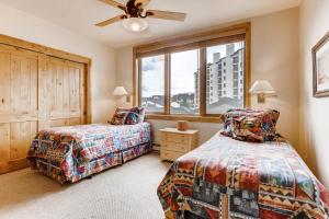 1 dormitorio con 2 camas y ventana en Torian Creekside III, en Steamboat Springs
