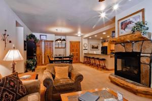 een woonkamer met een bank en een open haard bij Champagne Lodge in Steamboat Springs