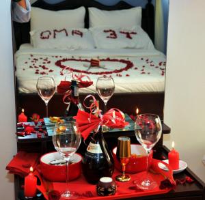 a table with wine glasses and candles in front of a bed at Victoria Lake View Guesthouse & Safaris in Entebbe