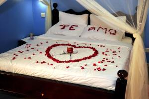 a bed with a heart made out of roses at Victoria Lake View Guesthouse & Safaris in Entebbe