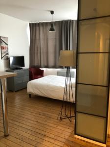 a bedroom with a bed and a desk with a lamp at Som-home in Péronne