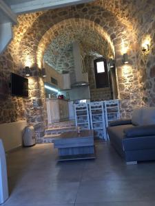sala de estar con sofá y pared de piedra en Elata Stone House en Eláta
