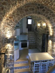 a kitchen with an archway in a stone building at Elata Stone House in Eláta