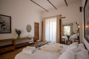 ein Schlafzimmer mit einem großen weißen Bett und einem Spiegel in der Unterkunft Hotel Sin Nombre in Oaxaca de Juárez