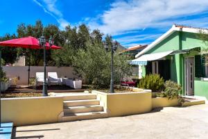 ein Haus mit einem roten Regenschirm und einer Terrasse in der Unterkunft Tamaris in Sevid