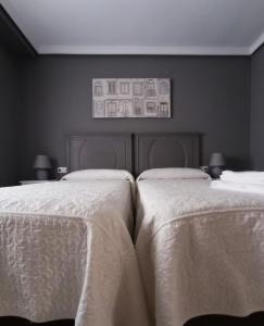 クエンカにあるDomus Cuencaの白いシーツが備わるベッドルームのベッド2台