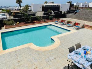 a swimming pool with a table and chairs next to it at CASA GECO in Playa Blanca
